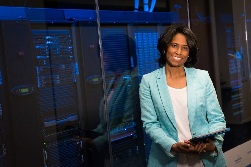 IMG_1693 Smiling woman in data center showcasing technology expertise.